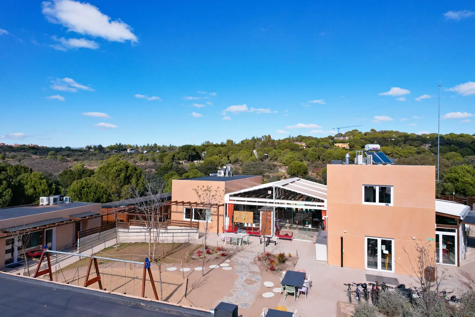 The school building from above, with the playground and the mountains behind.